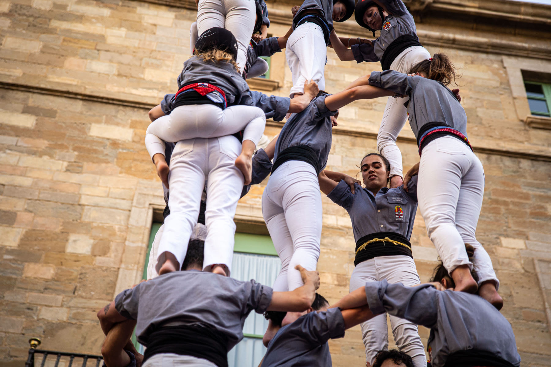 Castellers ascendiendo por el tronc del castell, vista en contrapicado