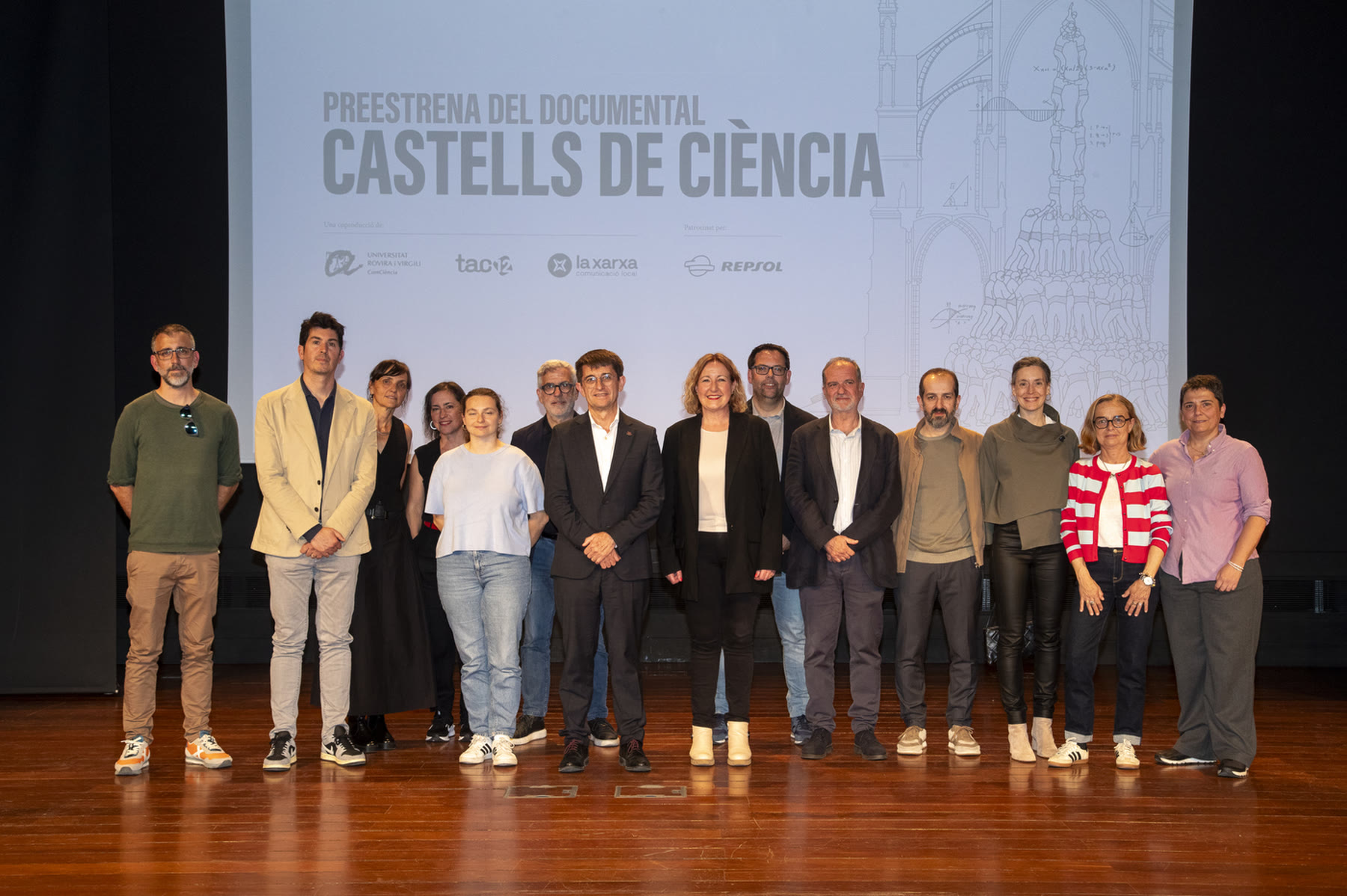 Equipo del documental Castells de ciència en su preestrena, con los logotipos de la URV, TAC12, La Xarxa y Repsol proyectados